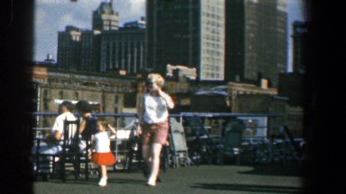 1961: woman walking on the rooftop of building in inner city area with kids