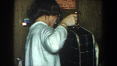 1960: two women gathering suitcases and bags and moving them while laughing