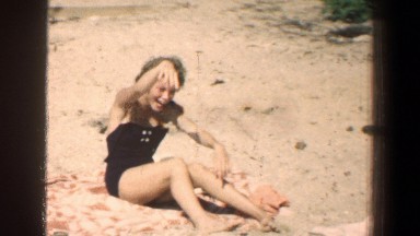 1961: People Sitting Together Laughing and Waving at Beach in Baltimore Maryland