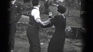 1938: Man Coaxes Girlfriend Into Dancing at Outdoor Gathering in Reading