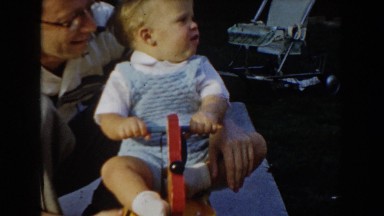 1962: dad and son playing on a rocking puppy toy. GLENDALE, CALIFORNIA