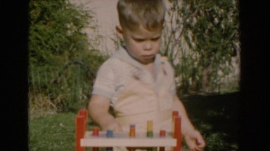 1962: boy child playing with toys in the yard on a sunny day GLENDALE