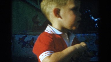 1962: little kid playing outside picking up small items and standing up looking