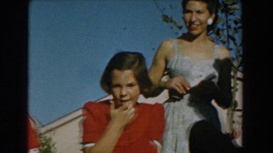 1962: boy concentrated on his toy being watched by a lady GLENDALE, CALIFORNIA