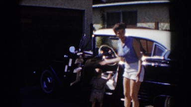 1962: a child sitting in the car waving with his mom out the door GLENDALE