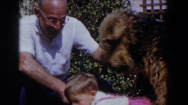 1962: elder man teaching a toddler how to greet a dog. GLENDALE, CALIFORNIA