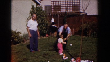 1962: grandfather playing with his grandson out in the yard. GLENDALE