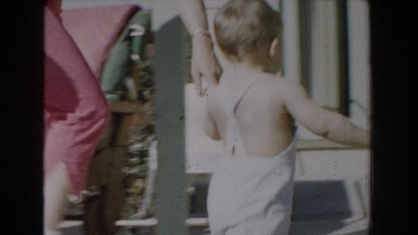 1962: baby wearing trousers walking through the veranda of the house GLENDALE