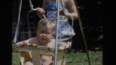 1962: a baby boy swimming in a swing in a yard GLENDALE, CALIFORNIA