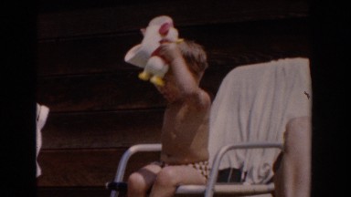 1962: mother and son outside on porch bonding with a duck toy VAN NUYS