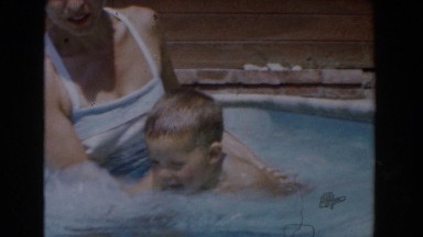 1962: a young boy learning to swim with his mom in a pool VAN NUYS, CALIFORNIA