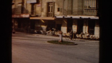 1960: Several Men Riding Down the Street Using Different Modes of Transportation