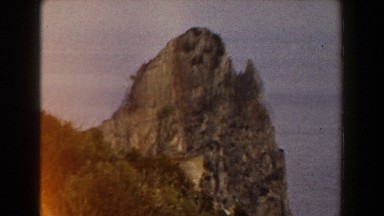 1960: a man picking up two women in joy while viewing a beautiful mountain