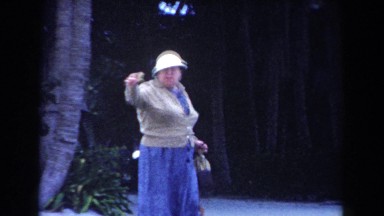 1960: woman talking and walking on the sidewalk. MIAMI, FLORIDA