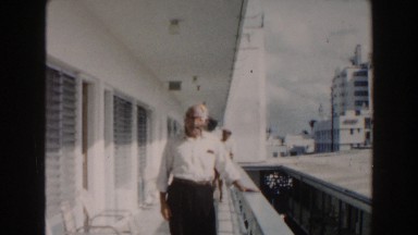 1960: man walking talking to cameraman along side building MIAMI, FLORIDA