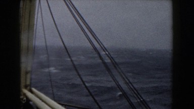 1959: Choppy Grey Ocean Waters Viewed From Side of Boat with Rope