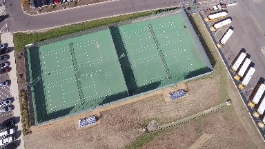 four large green tennis courts are seen from above COLORADO
