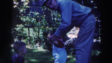 1964: Older Man Helps Toddler Walk in Tustin Wisconsin Backyard