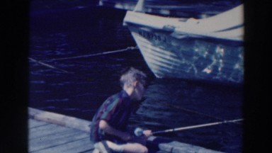 1964: Boy Fishing on a Large Body of Water in Tustin Wisconsin