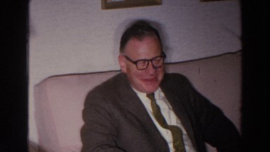 1966: man sitting down enjoying his company with other people while talking