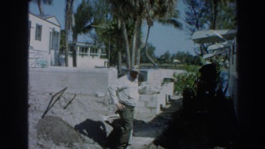 1966: old men push a large garden cart full of plants in a trailer