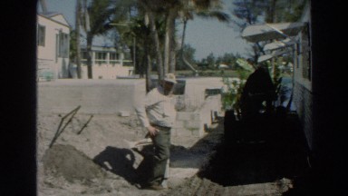 1966: view of a man standing beside his small home. PUERTO RICO