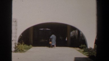 1960: woman walking into an abstract building. ISRAEL