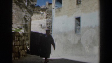1960: a woman wearing a long coat walking in the alley ISRAEL