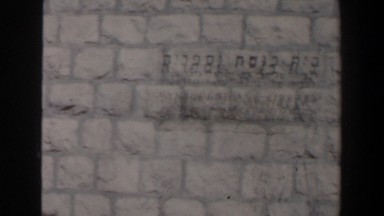 1960: light brick building with a lady standing out front. ISRAEL