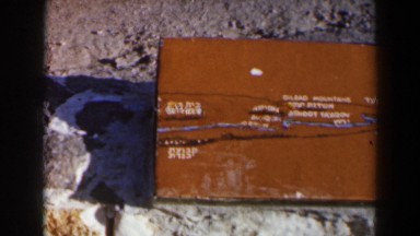 1960: wooden box painted in brown with some engravings on it on beach. ISRAEL