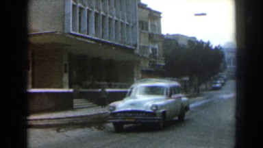 1960: A Motor Vehicle Driving on the Street Past a Building in Israel