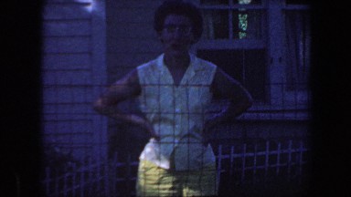 1959: Elderly Couple Pleasantly Smile and Wave Outside Home in Iowa