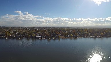 airplane view of a city with a large lake beside the city. COLORADO