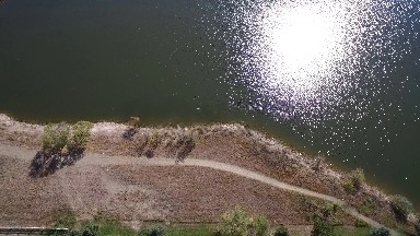 sun reflecting off of a lake along a shoreline. COLORADO