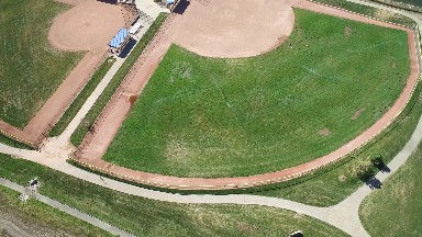 aerial view of a grassy area for sports entertainment near a body of water