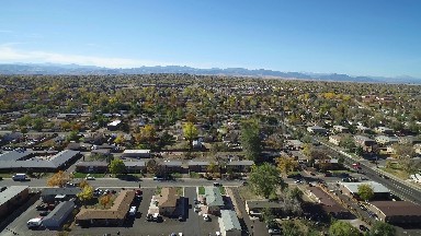 the panoramic view of a large city surrounded by mountain under the blue sky