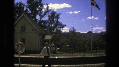 1975: a man walking in a yard in front of a flag pole SWEDEN