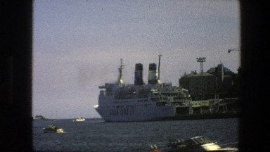 1975: a cruise ship moored at a dock in a harbor SWEDEN