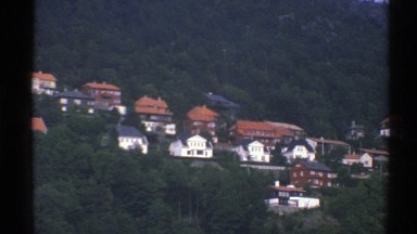 1976: vegetation on a hill along with many residential structures in a city