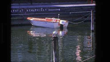 1975: Small Red and White Runabout Tied in Calm Danish Harbor