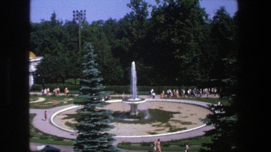 1975: people visit the garden with a fountain and building with gold dome