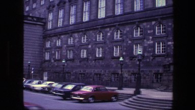1975: cars parked by large building COPENHAGEN