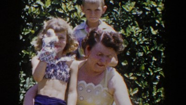 1953: little girl acting silly while on her mother's lap. LUBBOCK TEXAS