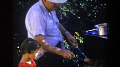 1953: man grilling while child watches LUBBOCK TEXAS
