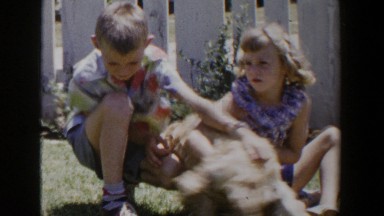 1953: vintage footage of kids playing in yard with their dog. LUBBOCK TEXAS