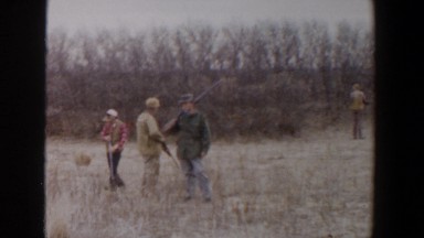 1956: four hunters are wading through the tall dry grass on a cloudy day LUBBOCK