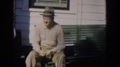 1951: Man Sharpening Knife While Sitting Outside in Cuba
