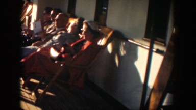 1951: several men and women sitting in lounge chairs on the deck of a cruise