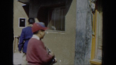 1951: Boy Wearing Cap and Holding Shoe-Shine Kit Turns Around Twice on Sidewalk