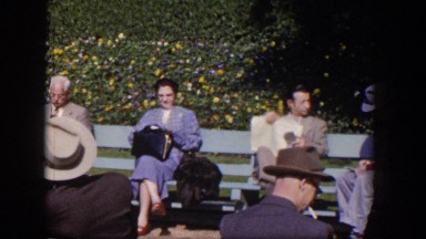 1954: group of random people sitting outside on a park bench. LAS VEGAS NEVADA